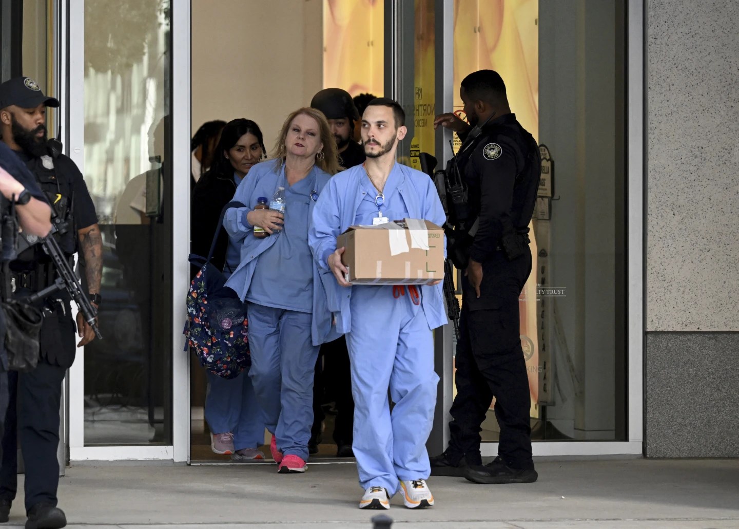 Law enforcement personnel wath as healthcare workers leave the Northside Hospital Midtown medical office building on May 3, 2023. (AP)