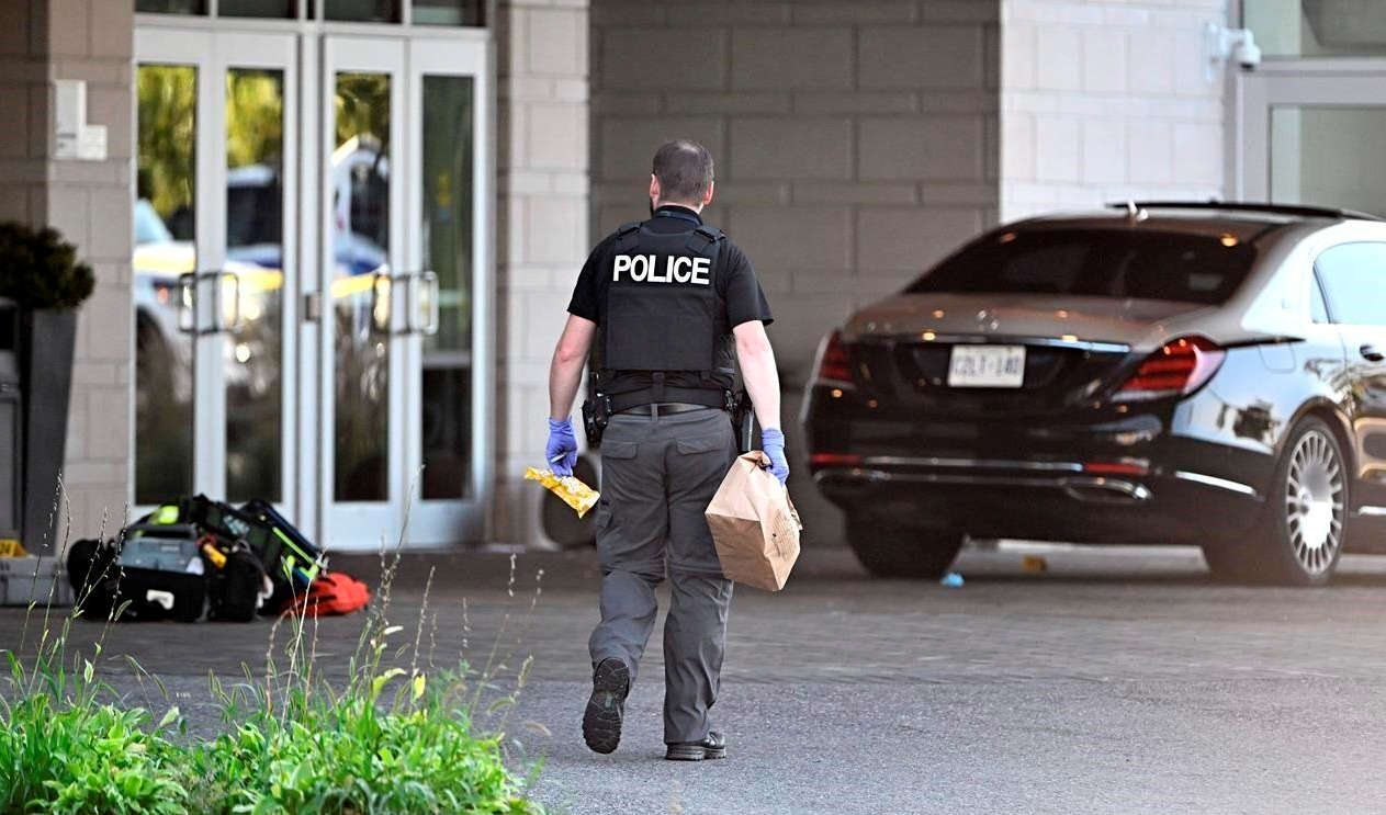 An Ottawa Police officer collects evidence after a Saturday night shooting at the Infinity Convention Centre that left two dead, in Ottawa, on Sunday, Sept. 3, 2023. (The Canadian Press)