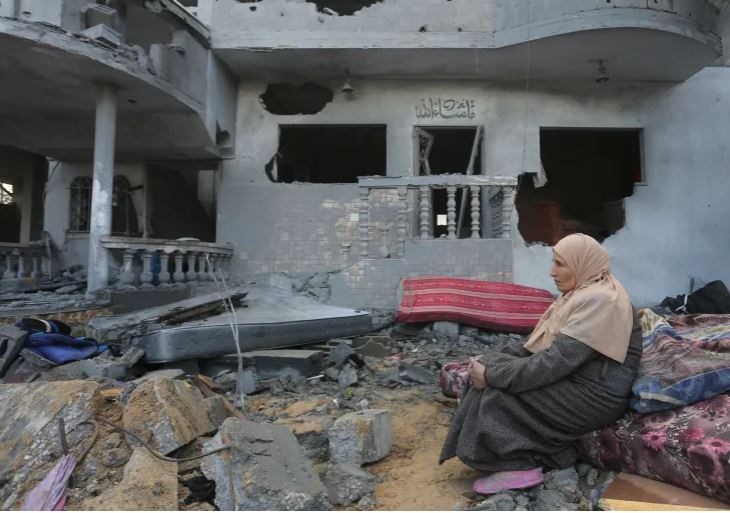 A Palestinian woman sits by houses destroyed in the Israeli bombardment of the Gaza Strip in Rafah on November 20,2023. (AP)