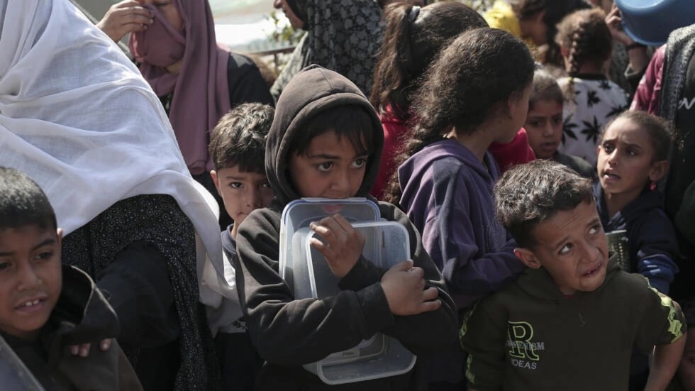 Palestinian children waiting in line for food amid Israeli genocide and starvation (AFP)