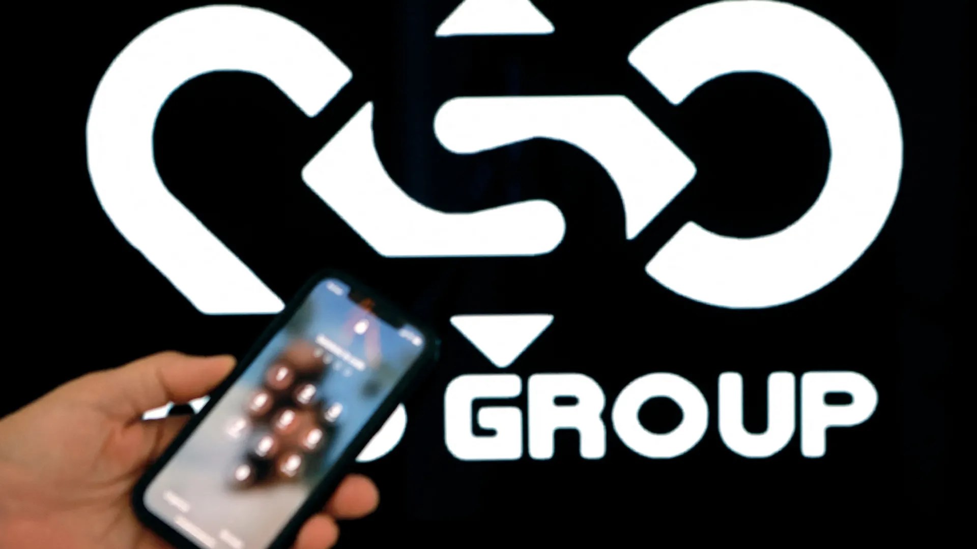 A person holding a phone showing the logo of Israeli spyware company NSO group. (AFP)